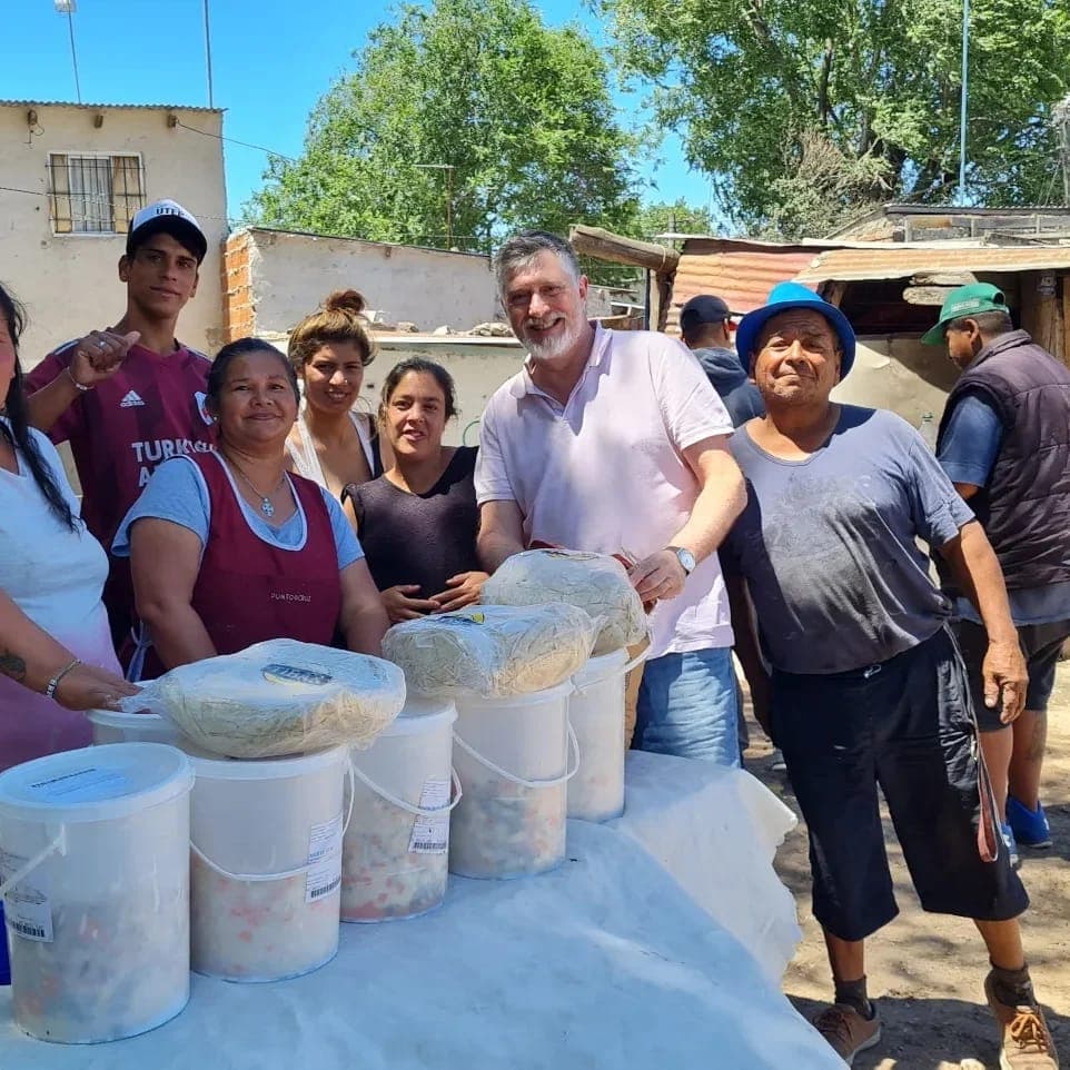 Personas agrupadas en torno a una mesa, con cubos, trabajando juntas en un proyecto o actividad.